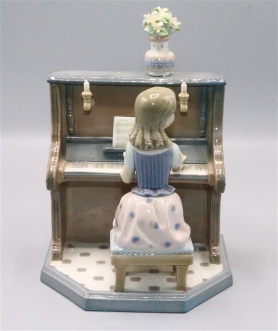 Lladro girl seated playing upright piano (with vase of flowers)